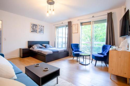 - un salon avec un lit et des chaises bleues dans l'établissement Appartement Moderne Champs-Élysées, à Paris