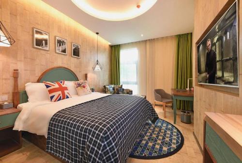 a bedroom with a large bed and a table and chairs at Mehood Theater Hotel, Jinan High -tech Zone Wanda Plaza in Jinan