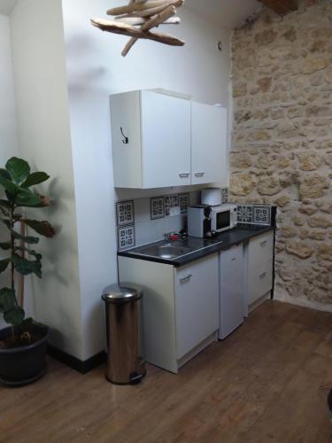 une cuisine avec des armoires blanches et un comptoir dans l'établissement Roquevaquiere - Ancienne Grange rénovée - Logement autonome, à Ouveillan