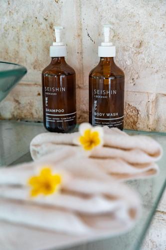 two bottles of seashore laundry detergent sitting on a counter with two hands at La Santa Rosa in Uluwatu