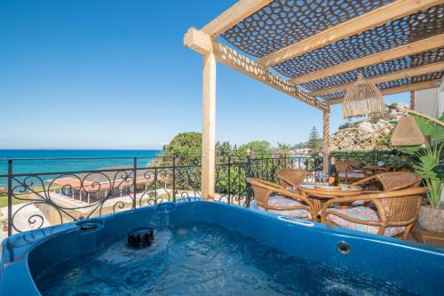 凱勒西的住宿－Casa di Cuore - Beachfront，阳台的热水浴池,配有桌椅