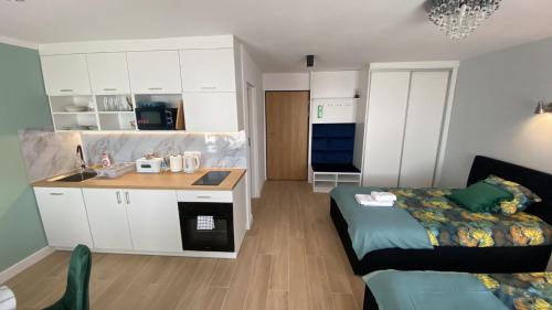 eine Küche und ein Wohnzimmer mit einem Bett und einem Waschbecken in der Unterkunft Metalowiec in Stalowa Wola