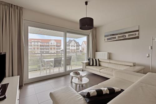 a living room with a couch and a large window at Villa Emilia 0206 P104 in Nieuwpoort
