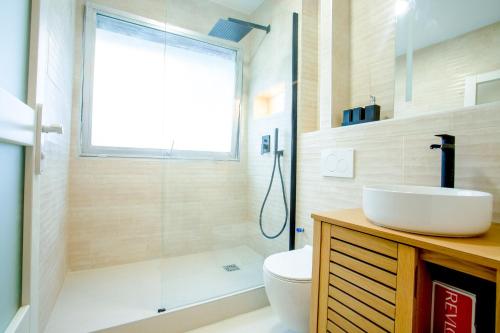 une salle de bain avec un lavabo, des toilettes et une douche dans l'établissement Appartement Moderne Champs-Élysées, à Paris