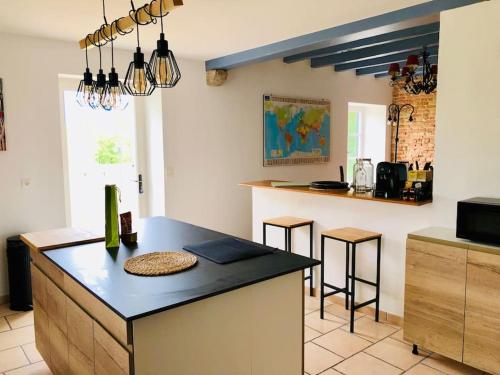 une cuisine avec un comptoir noir dans une pièce dans l'établissement Charmante maison familiale avec jardin et jacuzzi proche océan, à Saint-Martin-de-Seignanx