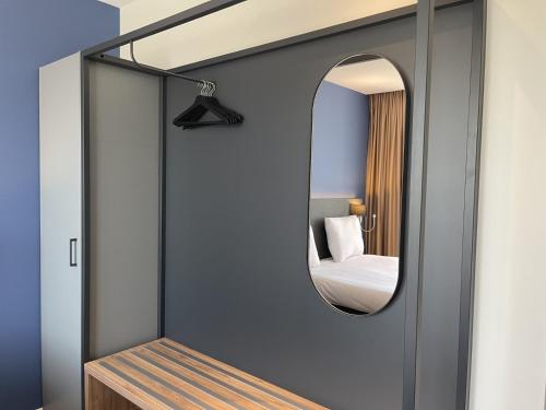 a mirror in a room with a bed at OZO Hotels Antares Airport in Hoofddorp