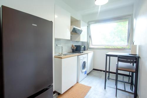 une petite cuisine avec une machine à laver et un évier dans l'établissement Appartement Moderne Champs-Élysées, à Paris