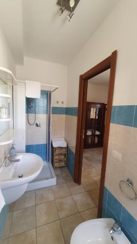a bathroom with a sink and a tub and a toilet at Blue Dolphin Guest House in Alghero