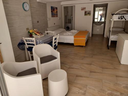 Habitación con cama, mesa y sillas. en Casa Soedo, en Torre dell'Orso