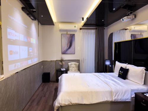 a hotel room with a bed and a projection screen at M&H Hotel in Ho Chi Minh City
