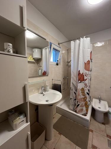 a bathroom with a sink and a toilet and a shower at Hiška na hribu in Ankaran