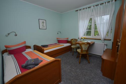 1 dormitorio con cama, mesa y ventana en Christel's Pension en Brandenburg