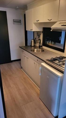 a kitchen with a sink and a stove top oven at Family vibes, op 5 sterren vakantiepark in Limburg in Sevenum