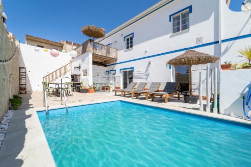 a swimming pool in front of a white house at Villa O Altinho Carrapateira in Carrapateira
