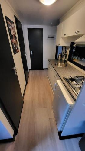 a small kitchen with a sink and a stove at Family vibes, op 5 sterren vakantiepark in Limburg in Sevenum
