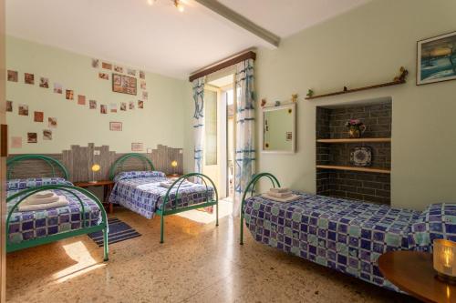 a room with two beds and a table and a fireplace at Sweet Honey Home by Halldis in Dongo