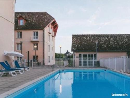 une piscine devant un immeuble dans l'établissement Appartement piscine cure thermale, à La Roche-Posay