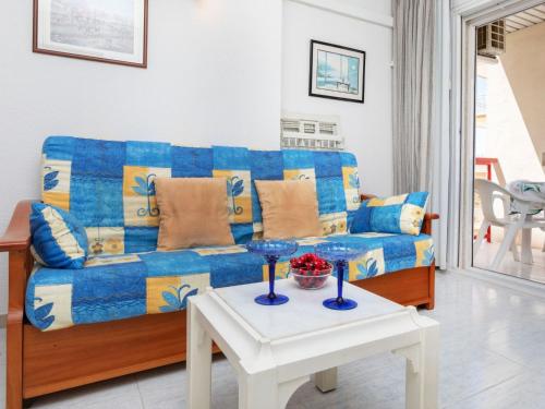 a living room with a blue couch and a table at Apartment Ancora by Interhome in Salou