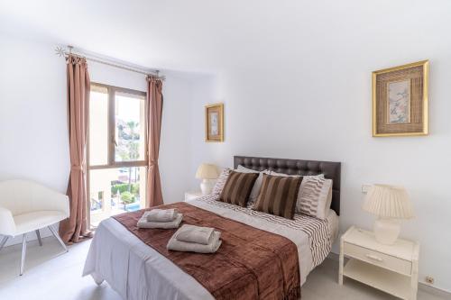 1 dormitorio con 1 cama grande y 2 toallas. en Veramar 2C, en Estepona