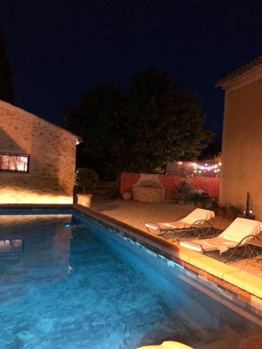 - une piscine avec 2 chaises longues la nuit dans l'établissement Mas en Provence, à Mondragon