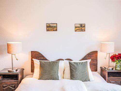a bedroom with a white bed with two lamps at Apartment Chesa Linaria by Interhome in Surlej