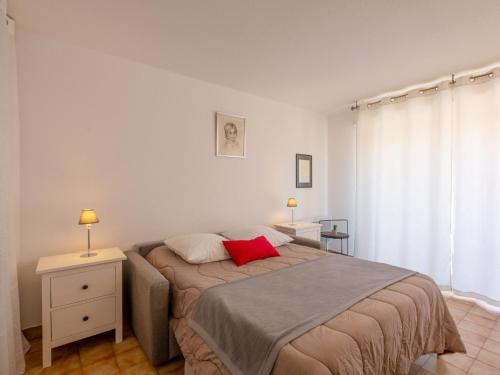 une chambre avec un lit avec un oreiller rouge dessus dans l'établissement Apartment La Palmeraie II-1 by Interhome, à Sainte-Maxime