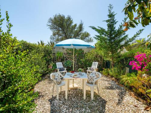 einen Tisch mit 2 Stühlen und einem Sonnenschirm in der Unterkunft Holiday Home Mandorleto by Interhome in Villasimius