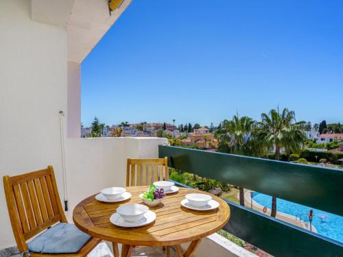 a wooden table and chairs on a balcony with a view at Apartment Lorcrisur by Interhome in Marbella
