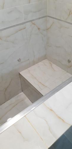 a glass shelf in a room with white marble at IMPERIAL ROOMS - ULTRACENTRAL - jacuzzi cu hidromasaj in Oradea