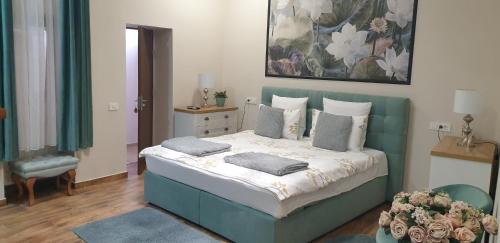 a bedroom with a bed with pillows and a painting at IMPERIAL ROOMS - ULTRACENTRAL - jacuzzi cu hidromasaj in Oradea