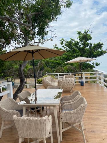 un tavolo e sedie con ombrellone su una terrazza di El Marie Villa a Bacnotan