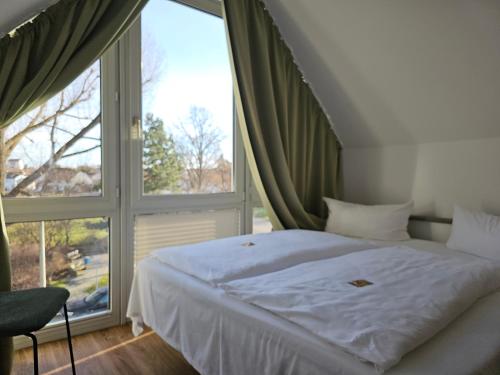 Bett in einem Zimmer mit einem großen Fenster in der Unterkunft Hotel Alpha in Nürnberg