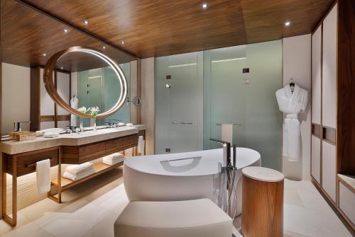 a bathroom with a sink and a toilet and a mirror at Conrad Rabat Arzana in Rabat
