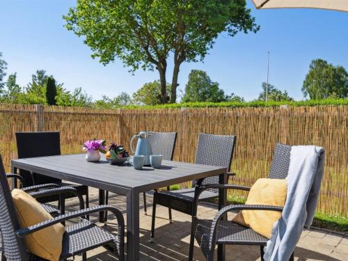 a table and chairs on a patio with a fence at Holiday Home Kolja - 525m from the sea by Interhome in Neder Lysabild