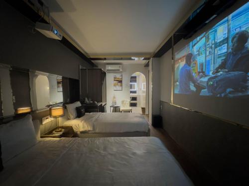 a hotel room with two beds and a large screen at M&H Hotel in Ho Chi Minh City