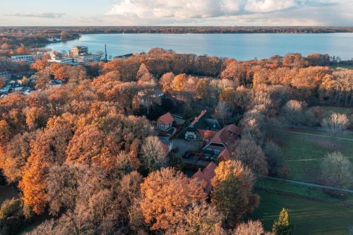 an aerial view of a house in a forest next to a lake at Ahrenshof Spieker W 11 in Bad Zwischenahn