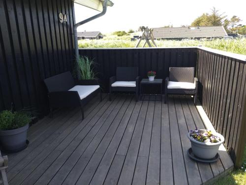 una terrazza in legno con 2 sedie e una pianta di Holiday Home Caro - 650m from the sea by Interhome a Hirtshals