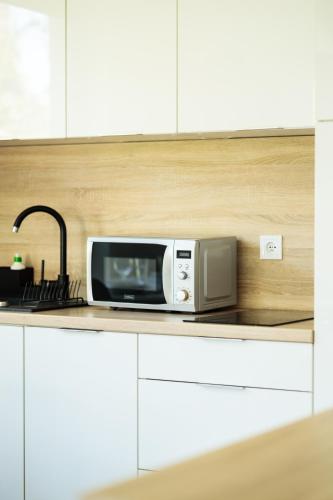a microwave sitting on a counter in a kitchen at Baltic Apartments in Pobierowo