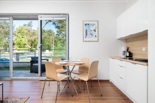 a kitchen and dining room with a table and chairs at Baltic Apartments in Pobierowo