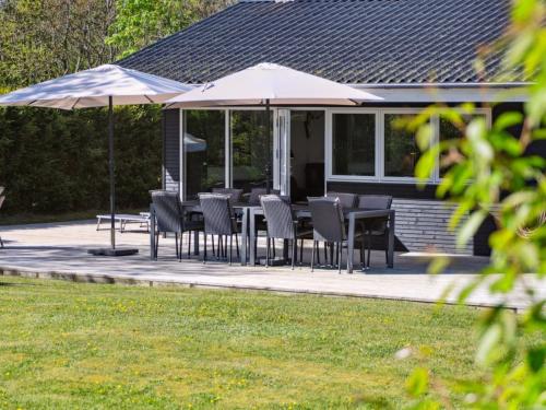 a group of chairs and umbrellas on a patio at Holiday Home Keti - 50m from the sea in NE Jutland by Interhome in Hadsund