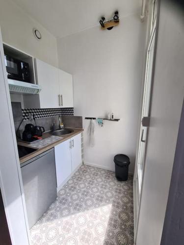 une petite cuisine avec des armoires blanches et un évier dans l'établissement Studio avec terrasse et place de parking, à Toulouse