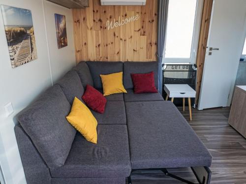 ein graues Sofa mit gelben und roten Kissen im Wohnzimmer in der Unterkunft Holiday Home Petra by Interhome in Wemding