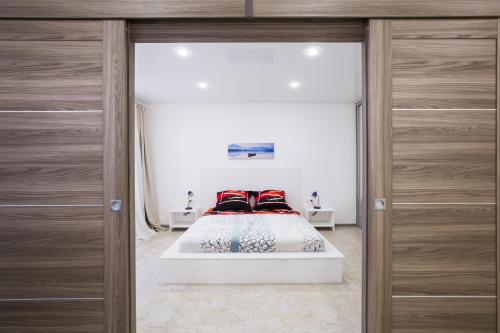 モスクワにあるWhite Sky Apartmentsの木製キャビネット付きの部屋にベッド付きのベッドルーム1室があります。