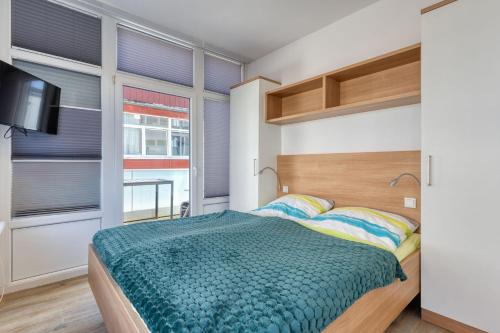 a bedroom with a bed and a flat screen tv at Alte Teestube 69 2 Raum in Norderney