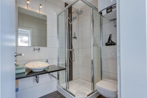 ein Bad mit einer Dusche, einem WC und einem Waschbecken in der Unterkunft Alte Teestube 69 2 Raum in Norderney