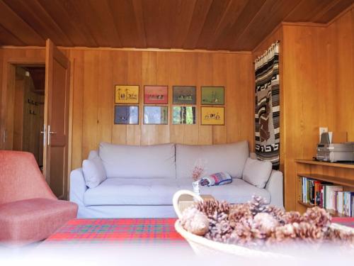 Apartment Chalet Colette-2 by Interhome في جريندلفالد: غرفة معيشة مع أريكة بيضاء ورف كتاب