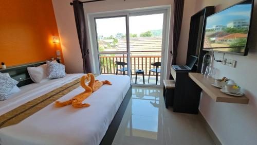 a hotel room with a toy monkey sitting on a bed at Duangjai Residence - SHA Extra Plus in Rawai Beach