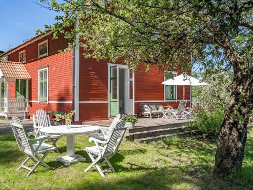 eine Terrasse mit einem Tisch, Stühlen und einem Sonnenschirm in der Unterkunft Holiday Home Idyllen - VML115 by Interhome in Skinnskatteberg