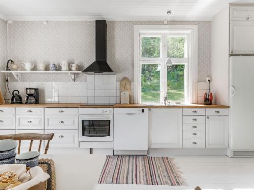 eine Küche mit weißen Schränken und einem Fenster in der Unterkunft Holiday Home Idyllen - VML115 by Interhome in Skinnskatteberg
