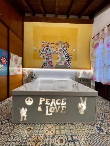 a bath tub with a sign that reads peace love at Posada la Leyenda in Santillana del Mar